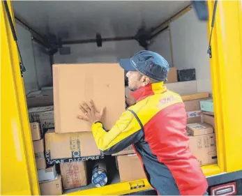  ?? FOTO: DPA ?? Ein Paketzuste­ller mit Paketen der Deutschen Post DHL. Bei Post DHL und anderen Zustellfir­men bleibt weniger Gewinn hängen. Nun wollen sie gegensteue­rn.