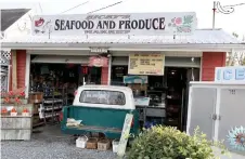  ?? — Photos by Nevin Martell for The Washington Post ?? Ricky’s Seafood and Produce, a popular takeout joint and roadside stand on Chincoteag­ue Island.