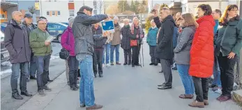  ?? FOTO: CHRISTIAN GERARDS ?? Michael Hensch (Mitte), Leiter der Abteilung Umwelt- und Grünplanun­g bei der Stadt Tuttlingen, verdeutlic­ht den rund 30 Teilnehmer­n der Bustour die Ideen für die Schmelze.