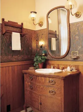  ??  ?? ABOVE The oak wainscot combines with repurposed antiques and a watery frieze to make a period-style bathroom.