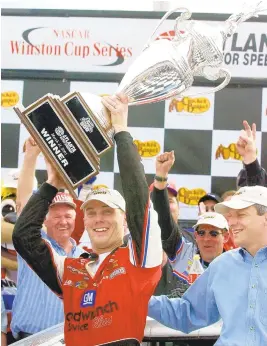  ?? RIC FELD/ASSOCIATED PRESS FILE ?? Kevin Harvick holds up the trophy in Victory Lane after winning his first Cup race in at Atlanta Motor Speedway in Hampton, Ga.