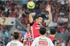  ??  ?? Milton Caraglio, autor del gol del Atlas, intenta cabecear ante la marca de un rival del Necaxa en el Jalisco. /IMAGO7