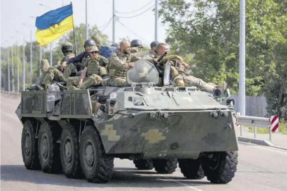  ?? (Photo: AP) ?? Ukrainian servicemen ride atop an armoured vehicle on a road in the Donetsk region, eastern Ukraine, Sunday, August 28, 2022. As the war slogs on, a growing flow of Western weapons over the summer is now playing a key role in the counteroff­ensive, helping Ukraine significan­tly boost its precision strike capability.