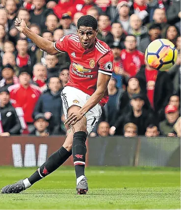  ??  ?? Manchester United's two-goal hero Marcus Rashford scores during yesterday’s clash against Liverpool. See Page 26