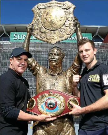  ?? PHOTO: DARREN ENGLAND/NEWS CORP AUSTRALIA ?? KING HIT: Jeff Fenech and Jeff Horn and the world title belt at the Wally Lewis statue outside Suncorp Stadium.