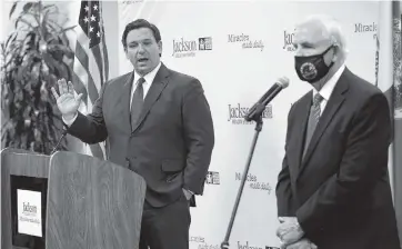  ?? CARL JUSTE cjuste@miamiheral­d.com ?? Gov. Ron DeSantis answers questions during a press conference on COVID-19 at Jackson Memorial Hospital with Miami-Dade Mayor Carlos Gimenez on Monday.