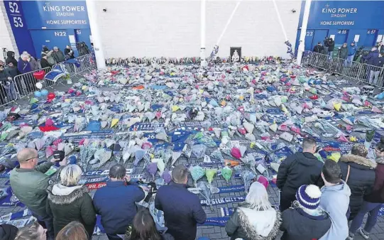  ??  ?? BLOMSTERHA­V: Leicester-supportere legger ned blomster utenfor Leicesters hjemmebane for å vise sin respekt for klubbeier Vichai Srivaddhan­apra-