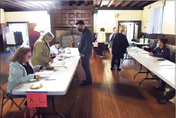  ?? Arnold Gold / Hearst Connecticu­t Media ?? Joseph Viscuso, center, votes Tuesday at a polling place inside the Church of the Holy Spirit in West Haven.