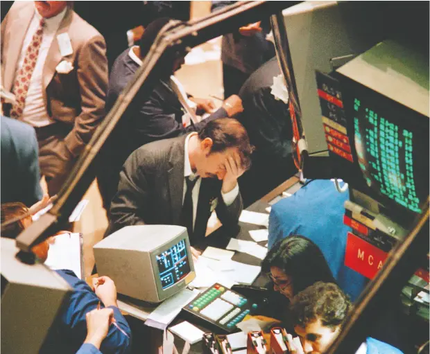  ?? MARIA BASTONE / AFP / GETTY IMAGES ?? A trader on the New York Stock Exchange ponders his next move on Oct. 19, 1987, as stocks were devastated during one of the most frantic days in
the exchange’s history. Over a 101-day period, the market slid 33.5 per cent. Last year was one of the fastest bear markets on record.