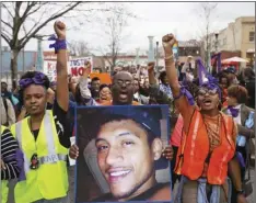  ?? aP PHoTo/DaVID GolDman ?? In this 2015 file photo, Brandon Marshall carries a photo of Anthony Hill as protesters march through the street demonstrat­ing Hill’s shooting death by a police officer, in Decatur, Ga.