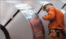  ?? CP PHOTO TARA WALTON ?? A Dofasco employee looks at rolls of coiled steel in Hamilton Ont., Tuesday.