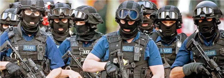  ??  ?? Rapid reaction force: Heavily armed and masked members of a police firearms team swarm around Borough Market and The Shard after Saturday’s terror attack