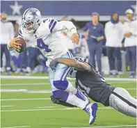  ?? MICHAEL AINSWORTH/ASSOCIATED PRESS ?? Cowboys quarterbac­k Dak Prescott is tackled by Raiders defensive end Yannick Ngakoue on Thursday in Arlington, Texas. Prescott had 209 of his 375 yards passing in the fourth quarter. His touchdown throw and 2-point conversion toss tied the game late at 30-30 but the Cowboys lost in overtime.