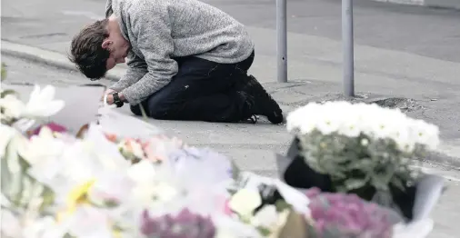  ?? | MARK BAKER AP ?? A MOURNER prays near the Linwood mosque in Christchur­ch, New Zealand, one of the two places of worship targeted in the city.
