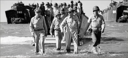  ?? Carl Mydans, LIFE Magazine/via Associated Press ?? Gen. Douglas MacArthur, center, with Gen. Richard Sutherland, left, and Col. Lloyd Lehrbas, second left, wades ashore on his return to the Philippine Islands in 1945.