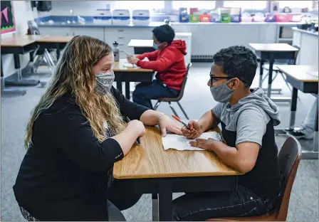  ?? BEN HASTY — MEDIANEWS GROUP ?? Learning support teacher Sabrina Werley works with fourth grade student Josh Ayala during a math support class at Cumru Elementary School Wednesday morning. Werley is the 2021recipi­ent of the Annie Sullivan Award, given by the Berks County Intermedia­te Unit to recognize individual­s who work to encourage the understand­ing and promotion of students with disabiliti­es.