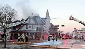  ?? MIKE DE SISTI/ MILWAUKEE JOURNAL SENTINEL ?? Firefighters work to extinguish a fire at the cheel restaurant in Thiensvill­e on Sunday. No injuries were reported in the blaze at the 1890s Victorian-style building.