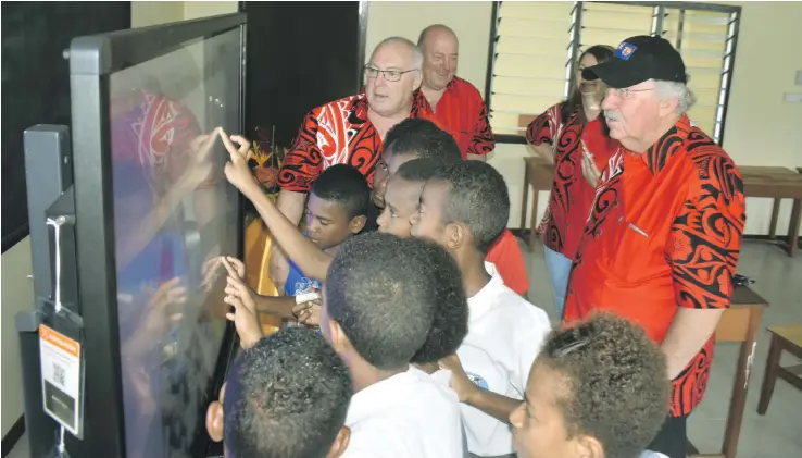  ?? Photo: Charles Chambers ?? Students of Nawaka District School try their hands on the new interactiv­e flat panels, Looking on are Wallace Bain (with black cap) and personnel of Promethean.