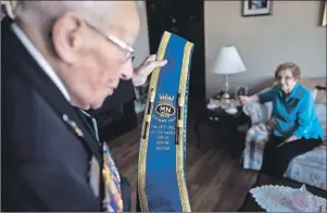  ?? CP PHOTO ?? Norman Crewe, 95, who served with the Merchant Navy throughout the Battle of the Atlantic, prepares his naval sash in front of his wife Millie in their home in Halifax recently.