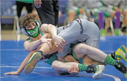  ?? PHOTOS BY LUIS SÁNCHEZ SATURNO/THE NEW MEXICAN ?? Concerns over the coronaviru­s pandemic prompted state officials to suspend the high school wrestling season Thursday, a suspension they lifted just hours later. Teams were back on the mat Tuesday as St. Michael’s hosted a three-team meet that included this match between Pojoaque’s Sergio Mesa, left, and Moriarty’s David Vaquera. Vaquera won by pin.