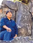  ??  ?? Phoebe Suina of Cochiti Pueblo sits by prehistori­c petroglyph­s at La Cieneguill­a, on the outskirts of Santa Fe.