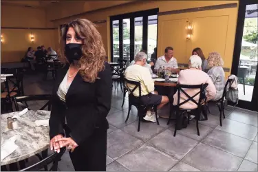  ?? Arnold Gold / Hearst Connecticu­t Media ?? Heidi Heidkamp, general manager of of Viron Rondo Osteria in Cheshire, stands in one of the restaurant’s indoor seating areas on Monday. State restrictio­ns on restaurant operations are expected to ease soon.