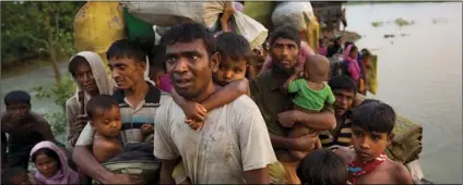  ??  ?? In this Nov. 1, file photo, Rohingya Muslims carry their young children and belongings after crossing the border from Myanmar into Bangladesh, near Palong Khali, Bangladesh. New satellite imagery of Myanmar’s Rakhine state shows the country’s...