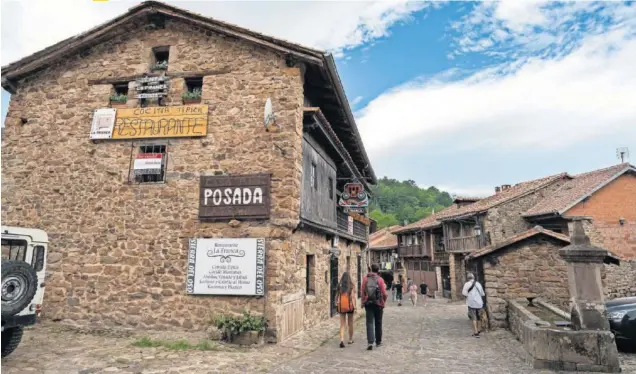  ??  ?? Unos turistas pasean por las calles empedradas de Bárcena Mayor, en el valle de Cabuérniga, en Cantabria.