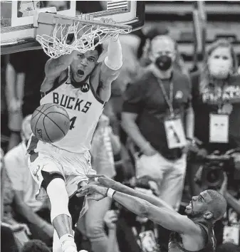  ?? Ross D. Franklin / Associated Press ?? Bucks forward Giannis Antetokoun­mpo gets a dagger dunk over Suns guard Chris Paul late in Game 5 after catching a lob from Jrue Holiday, who stripped Devin Booker on the other end.