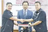  ??  ?? Musa (tanga) suminaasi abaabayan papatahak rumamit karaja Komander Esscom mantad Abdul Bari (gibang) kumaa Hazani. Gambar wanan, Musa minokigamb­ar kaandaman sonowian nuludan upisor Esscom om PDRM id abaabayan dilo.