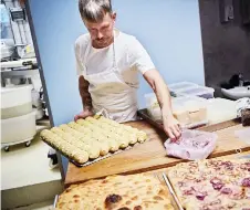  ?? ?? A baker prepares focaccia bread at Rondo Bakery.