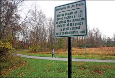  ?? PETE BANNAN — DIGITAL FIRST MEDIA FILE PHOTO ?? Signs in Kardon Park in Downingtow­n warn trail users not to leave the paved trail due to contaminat­ed soil in the Ponds section of the park.