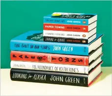  ?? ERIC HELGAS/NEW YORK TIMES ?? Mini-book versions of works by John Green are compared with full-size counterpar­ts. They can be read with one hand, the text flows horizontal­ly, and you can flip the pages upward, like swiping a smartphone.