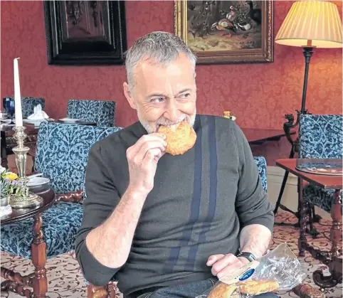  ?? ?? DELICACY: Celebrated chef Michel Roux Jr gets his teeth into an Aberdeen rowie during his visit to Inverlochy Castle.