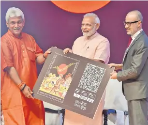  ?? PTI ?? Prime Minister Narendra Modi receives his Q card from Telecom Minister Manoj Sinha during the launch of India Post Payments Bank, in New Delhi on Saturday. —