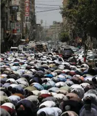  ??  ?? People attend Friday prayers yesterday along a road in Karachi, after the authoritie­s re-imposed lockdowns in selected areas in an effort to stop the spread of the coronaviru­s disease.