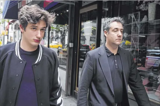  ?? Jonathan Carroll The Associated Press ?? Michael Cohen, right, President Donald Trump’s former personal attorney, walks down the street with his son Jake after leaving his apartment Saturday in New York. Cohen is scheduled to report to a federal prison Monday.