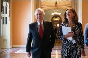  ?? The Associated Press ?? HARD-WON BUDGET DEAL: Senate Majority Leader Mitch McConnell, R-Ky., accompanie­d by Sharon Soderstrom, his chief of staff, smiles Thursday at the Capitol in Washington after a vote on a hard-won budget deal that would permit the government to resume borrowing to pay all of its obligation­s and would remove the prospect of a government shutdown in October.