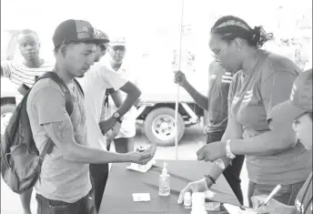  ??  ?? A citizen receives pills at Thursday’s launch. (DPI photo)