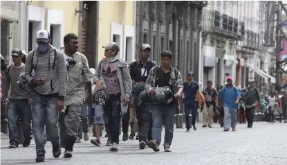  ?? AGENCIA ENFOQUE ?? Migrantes caminaron por las calles de la ciudad para continuar su ruta.