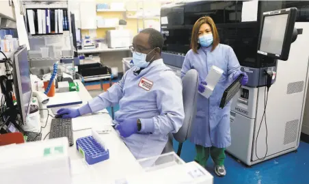  ?? Photos by Josie Lepe / Special to The Chronicle ?? Kenji Obadia Mfuh (left) and Suzette Santos, a senior lab scientist, process pool samples at Stanford Clinical Virology Lab.