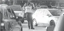  ?? JASON KRYK ?? A Windsor police officer directs traffic on Dominion Boulevard at Northwood Street in Windsor on Wednesday.