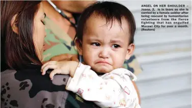  ??  ?? ANGEL ON HER SHOULDER – Joana, 2, is in tears as she is carried by a female soldier after being rescued by humanitari­an volunteers from the fierce fighting that has engulfed Marawi City for over a month. (Reuters)