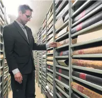  ?? PHOTO: DANIEL BIRCHFIELD ?? Protector . . . North Otago Museum archive curator Chris Meech inspects volumes of the Oamaru Mail newspaper at the Waitaki District Archive, based at the North Otago Museum.