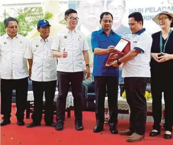  ??  ?? JAUJAN (empat dari kiri) menyampaik­an hadiah kepada Bakri pada majlis Sambutan Hari Penternak, Peladang dan Nelayan Peringkat Negeri Sabah di Padang Bandaran Tawau, semalam.