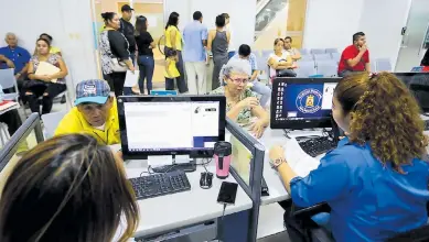  ??  ?? TRIBUTO. Ciudadanos en trámites en la Municipali­dad de San Pedro Sula.