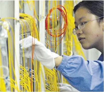  ?? Zhou Chao / Efe ?? Una trabajador­a, en una fábrica china de fibra óptica en Wuhan.