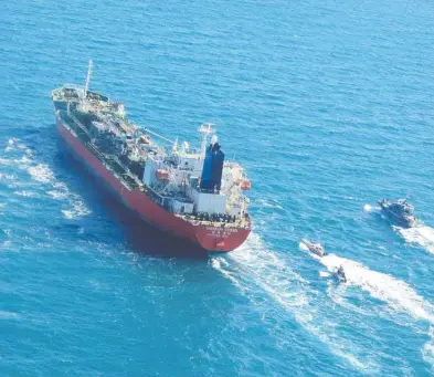  ?? TASNIM NEWS / AFP VIA GETTY IMAGES ?? A South Korean-flagged tanker is escorted by Iran's Revolution­ary Guards navy after being seized in Persian Gulf
waters Monday, with Iran claiming the vessel was polluting the gulf with chemicals.