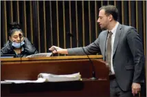  ?? ?? Assistant Macomb County Prosecutor Anthony Servitto hands a copy of a photograph to witness Hannah Archer on Wednesday at the joint murder trial for Dajuan Davenport and Darrell Banks in the deaths of Dionna Davis and Dazhane Holloway over two years ago at a Clinton Township apartment complex.