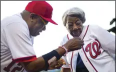  ?? PABLO MARTINEZ MONSIVAIS/AP PHOTO ?? Washington Nationals manager Dusty Baker helps Virginia McLaurin, 107, with her jersey on the field before the Nationals’ baseball game against the St. Louis Cardinals, on May 26, 2016, at Nationals Park in Washington.